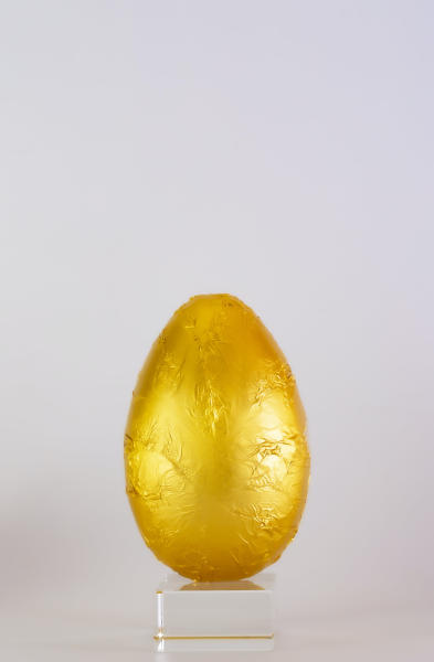 EIn goldenes Ei auf einer kleinen Anrichte, als Symbol für das Thema Glücksgedichte.