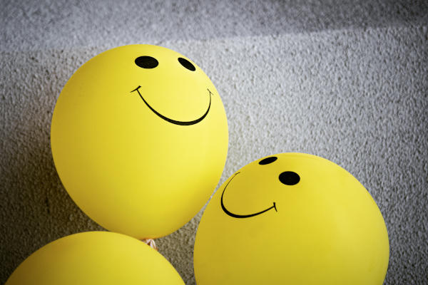 Gelbe Luftballons mit aufgedruckten Smileys